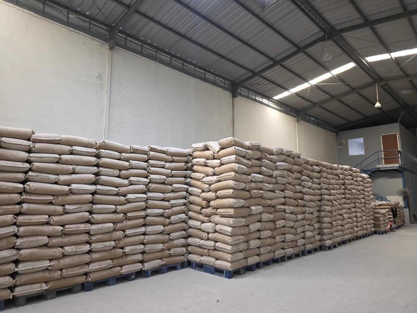 Rows of palletized industrial material bags stored in a warehouse