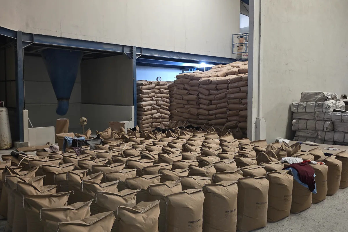 Open industrial material bags arranged near warehouse handling equipment